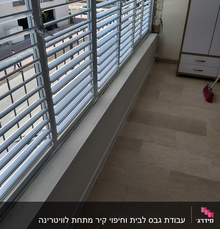 קיר גבס ליד חלון עם תריסים